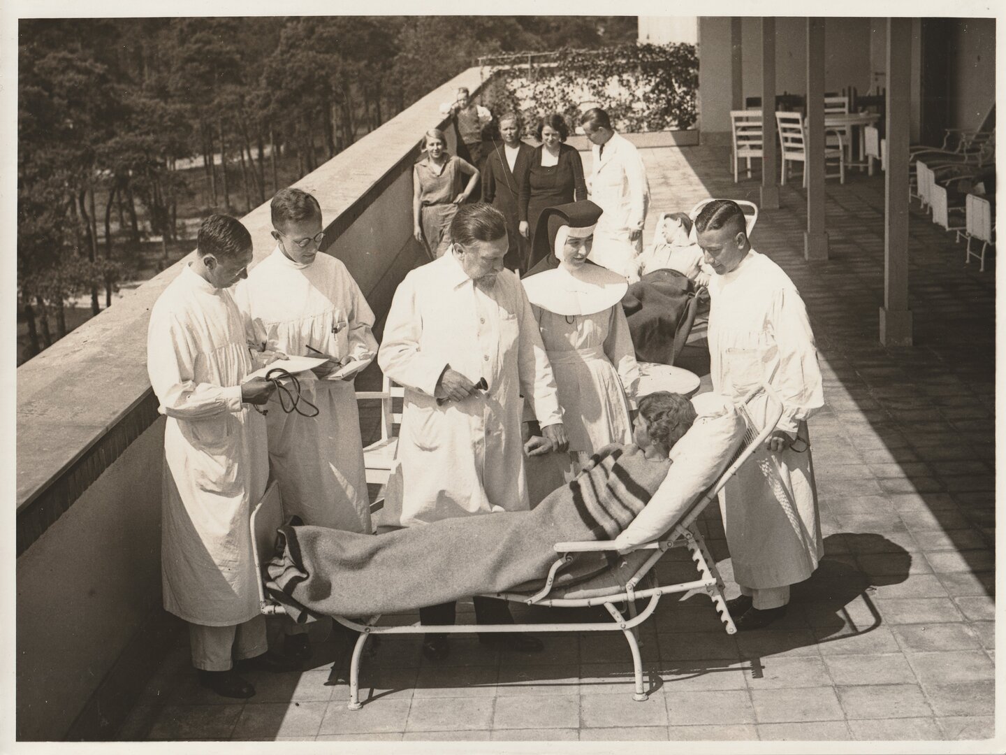Paul Lazarus und Kollegen im Gespräch mit einer Patientin auf der Liegeterrasse, 