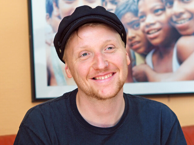 Ein Student sitzt mit seiner Instrumententasche im Café K.