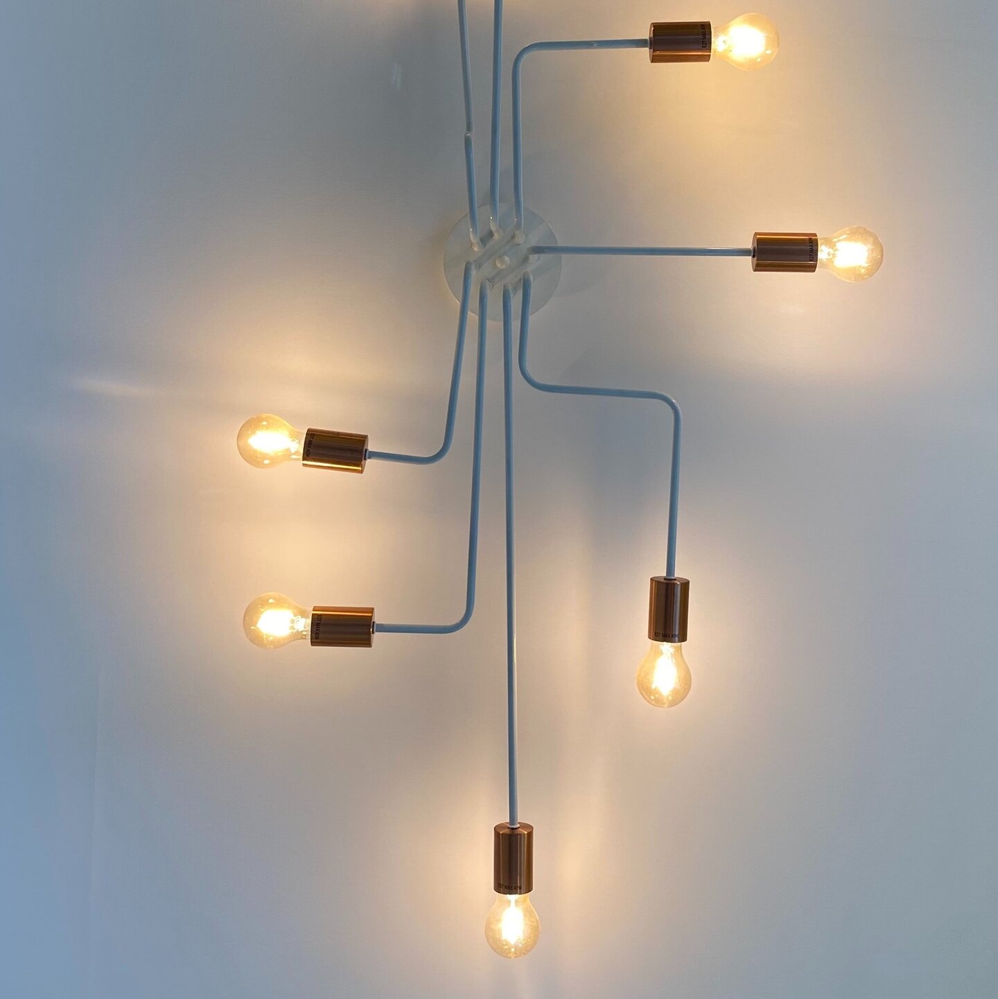 Glühbirnen sind an der Wand angebracht und miteinander verbunden.