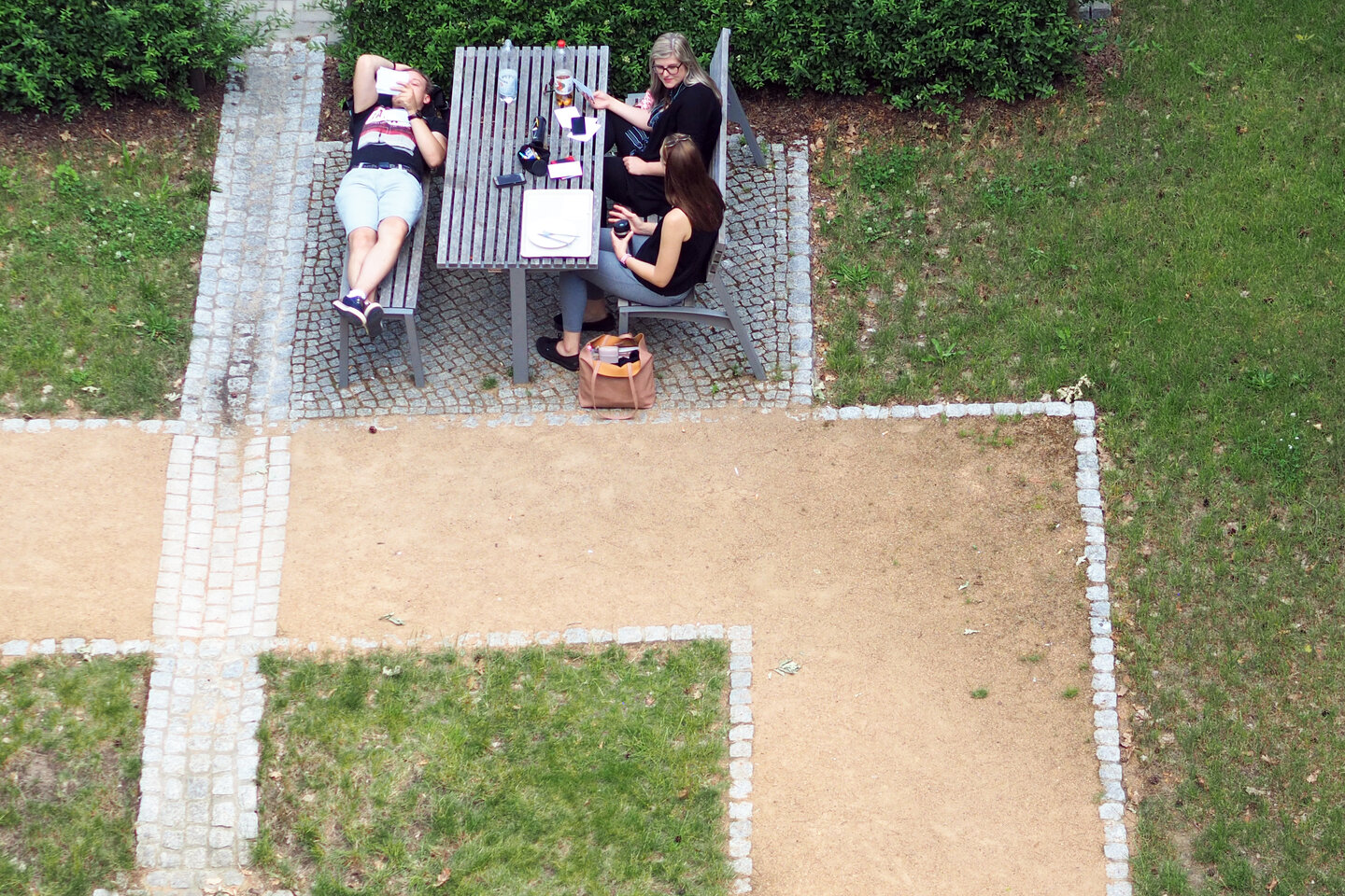 Studierende machen Pause auf der Bank im Innenhof der KHSB.