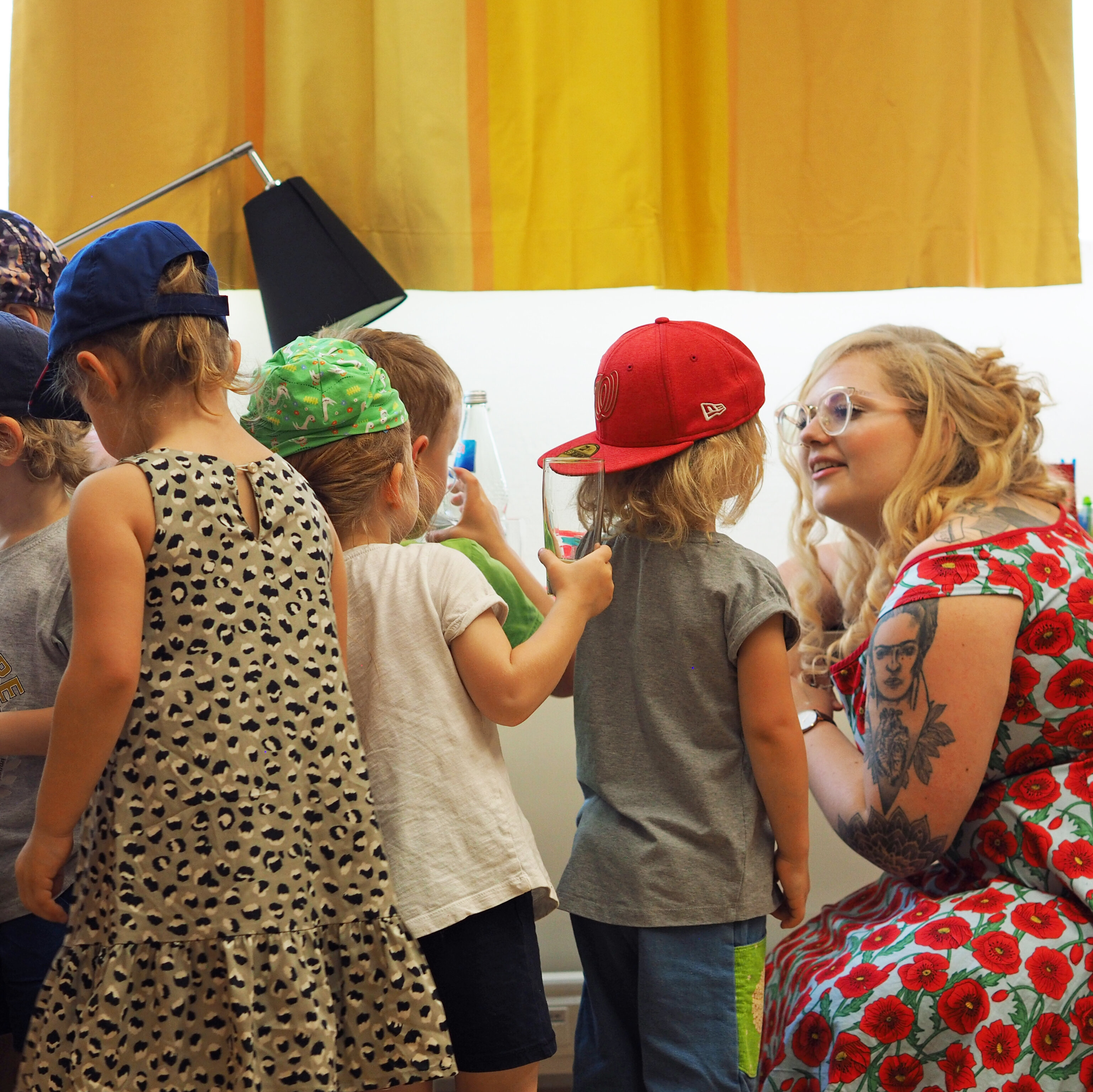 Eine Studentin spricht mit einer Gruppe Kindern.