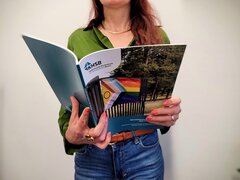 Frau hält Rechenschaftsbericht der KHSB in den Händen