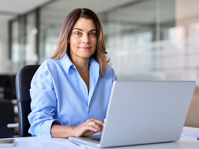 Frau arbeitet im Büro am Laptop