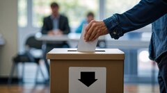 Wahlzettel wird in Urne gesteckt.