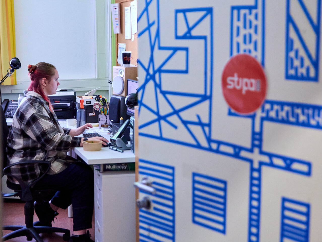 Studierende sitzt im Büro der StuPa mit halb geöffneter Tür.