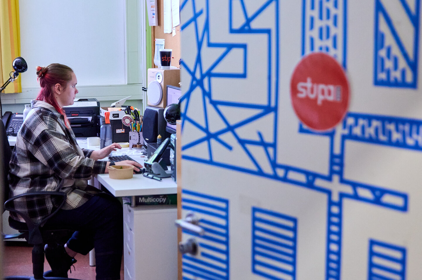 Studierende sitzt im Büro der StuPa mit halb geöffneter Tür.