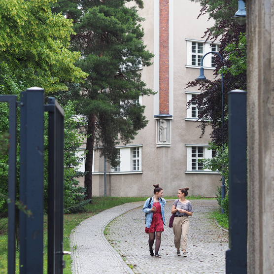 Zwei Studierende auf der Auffahrt vor der Hochschule