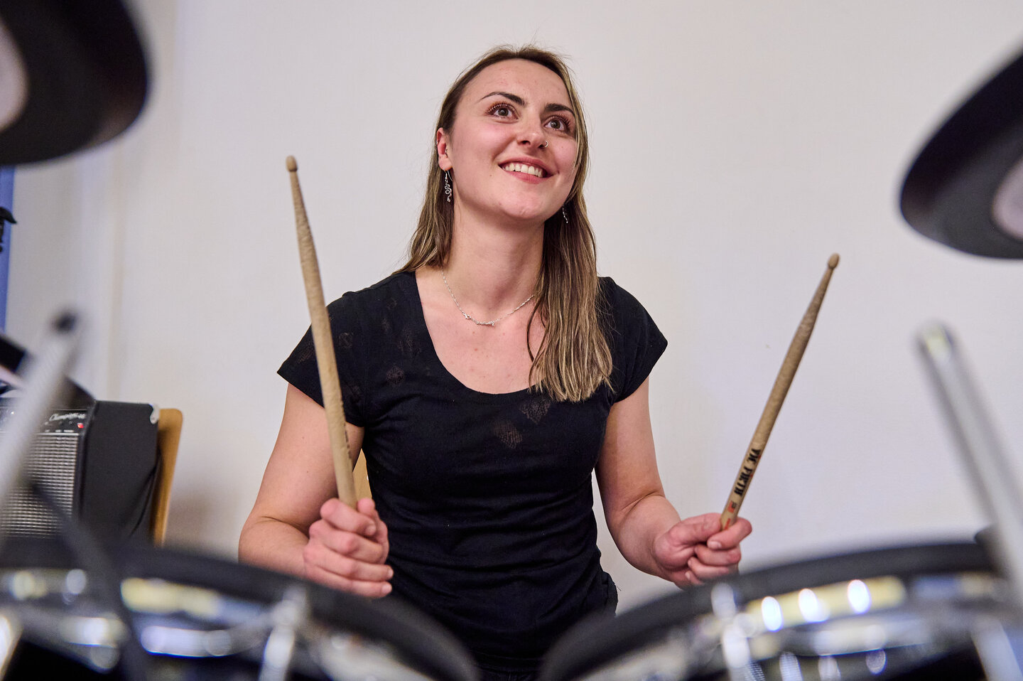 Die Schlagzeugerin der KHSB Hochschulband spielt Schlagzeug während eines Auftritts.