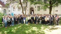 Gruppenbild der rund 70 Teilnehmenden auf einer grünen Wiese im Halbschatten.