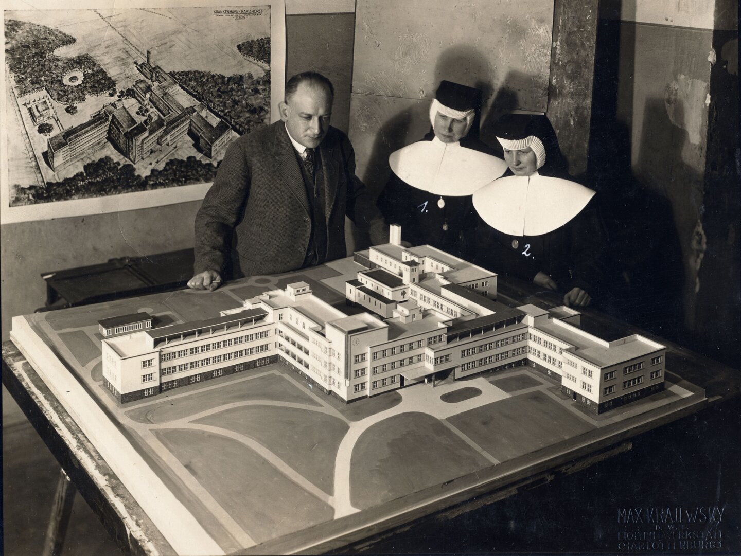 Mehrere Personen stehen um ein Modell des St. Antonius-Krankenhauses und betrachten es.