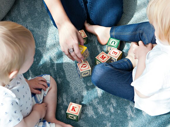 Kinder spielen mit Buchstabenwürfeln