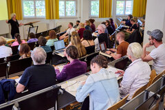Studierende sitzen im vollen Hörsaal der KHSB.
