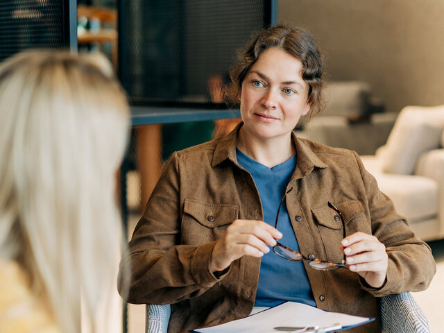 Frau hört Klientin im therapeutischen Setting zu