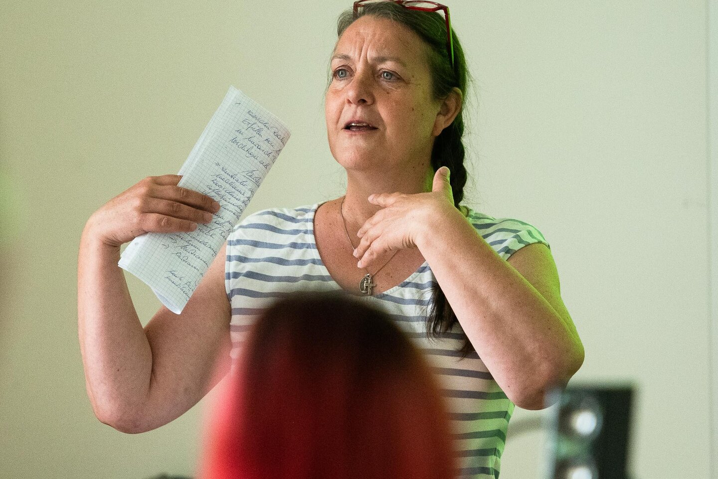 Eine Person steht vor der Seminargruppe und gestikuliert mit den Händen.