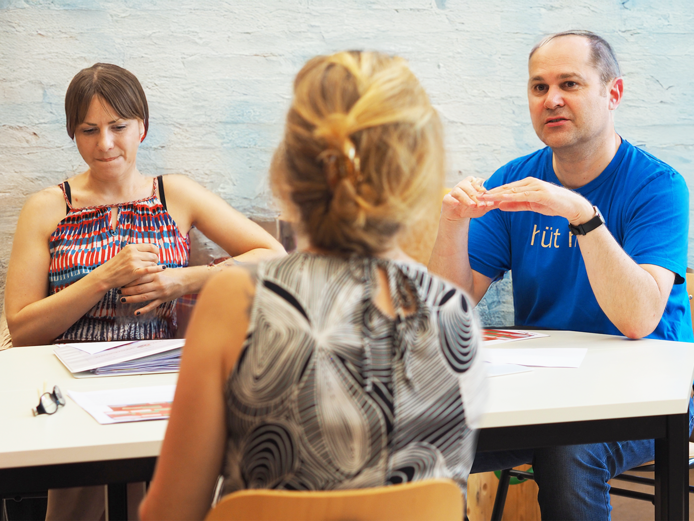 Personen diskutieren an einem Arbeitstisch