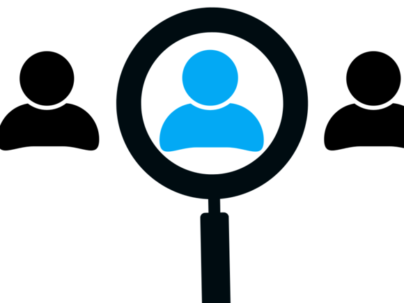 Ein Arbeitnehmer wird mit einer Lupe hervorgestellt