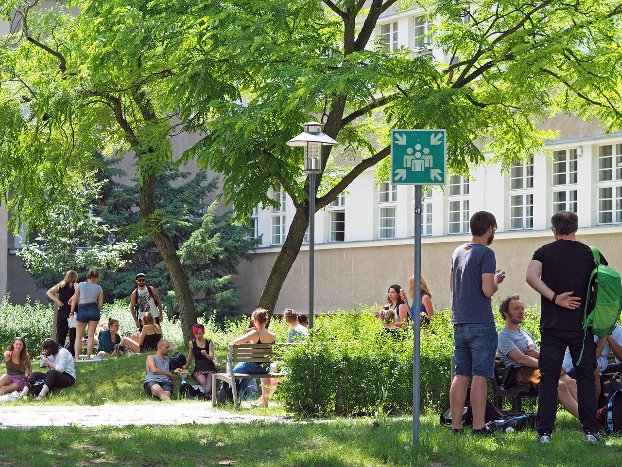 Studierende stehen im Innenhof der KHSB und unterhalten sich.
