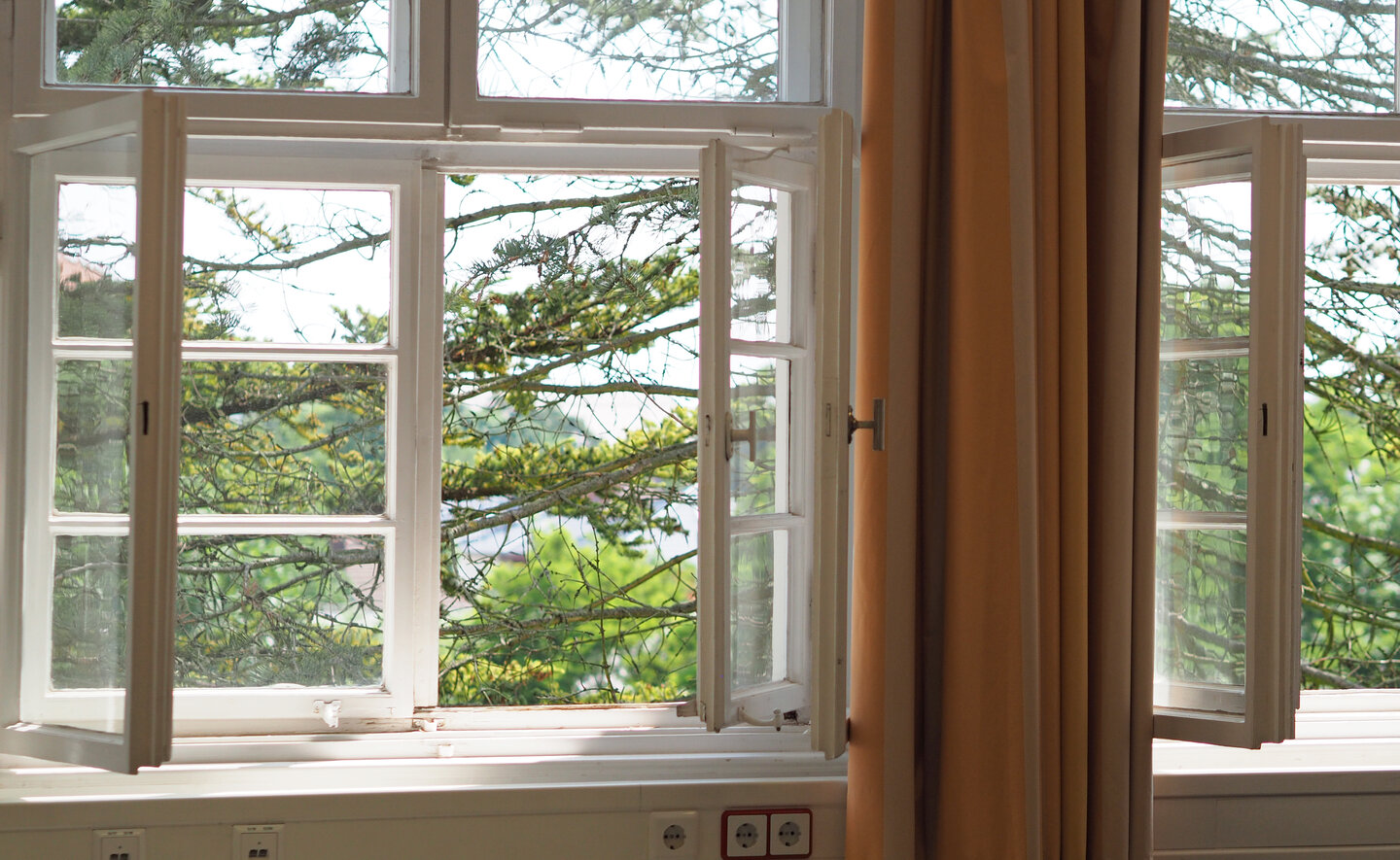 Zwei geöffnete Fenster mit Blick auf den Innenhof der KHSB.
