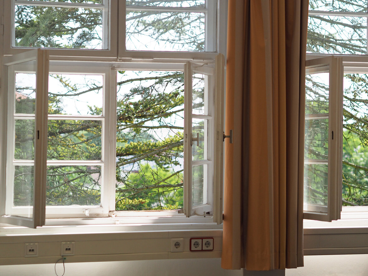 Zwei geöffnete Fenster mit Blick auf den Innenhof der KHSB.