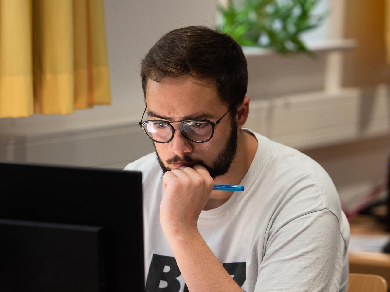 Student sitzt in der Bibliothek am Computer
