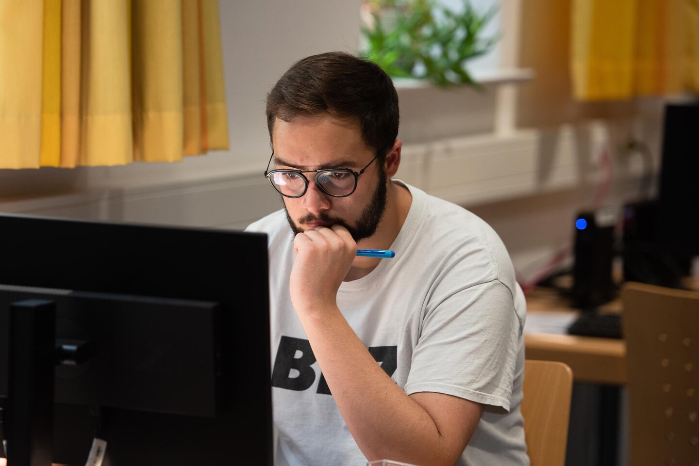 Student sitzt in der Bibliothek am Computer