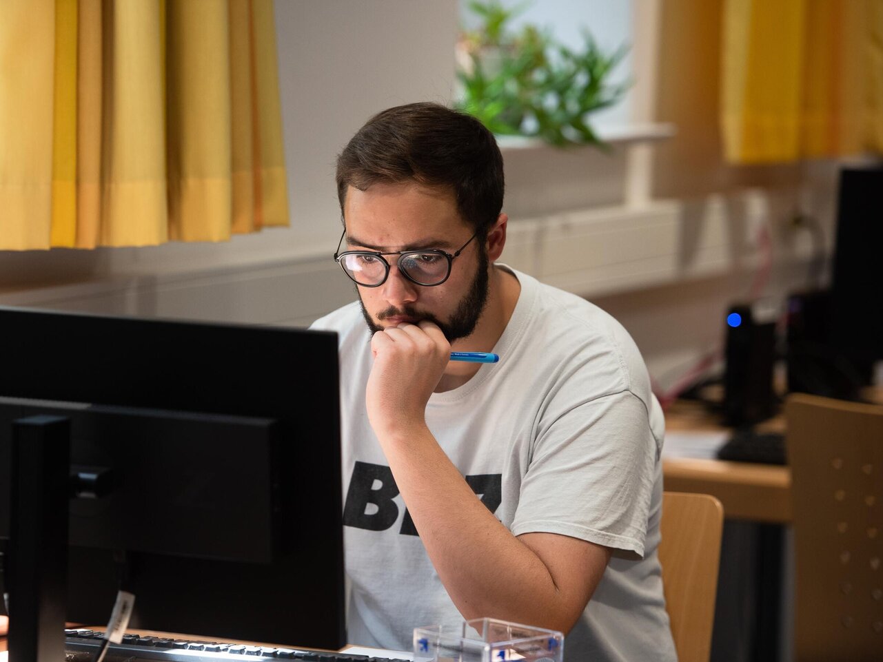 Student sitzt in der Bibliothek am Computer