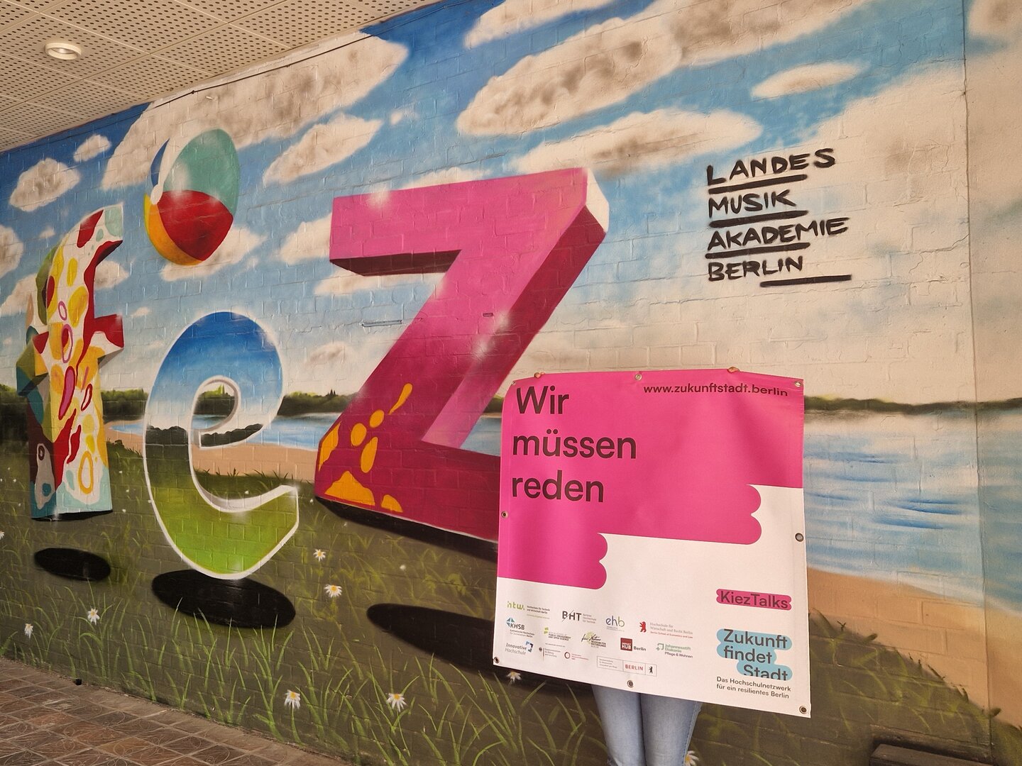 Eine Person hält ein großes Banner mit der Aufschrift "Wir müssen reden."