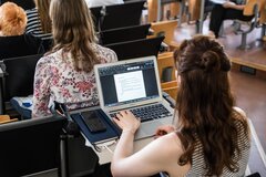 Studentin schreibt im Hörsaal am Laptop