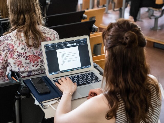 Studentin schreibt im Hörsaal am Laptop