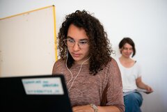 Studentin arbeitet am Laptop mit Kopfhörern