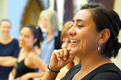 Eine lächelnde Studentin sitzt im Seminar in der Aula der KHSB.