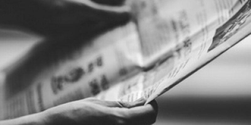 zwei Hände halten eine Zeitung