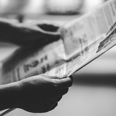 zwei Hände halten eine Zeitung