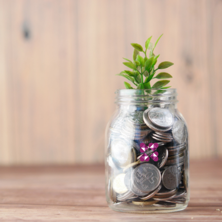 Glas mit Geld aus dem eine Pflanze wächst