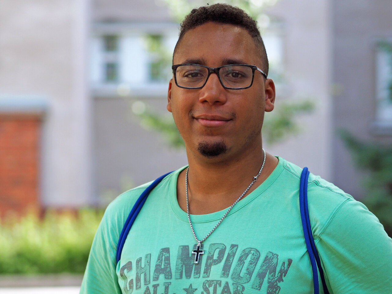 Ein Student steht im Innenhof der KHSB und lächelt. 