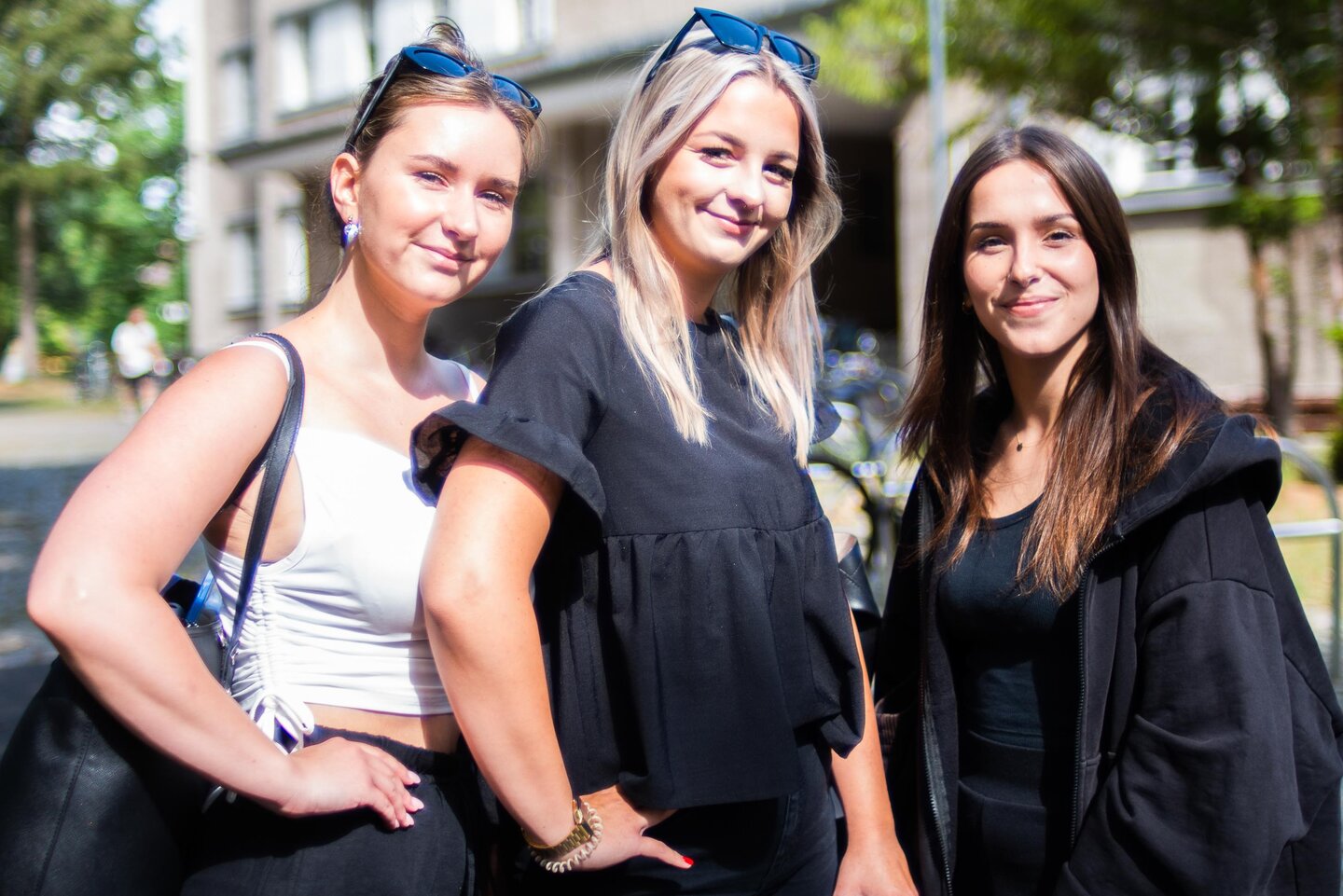 Drei freundlich lächelnde Studentinnen stehen vor dem KHSB-Gebäude.