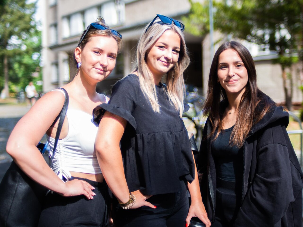 Drei freundlich lächelnde Studentinnen stehen vor dem KHSB-Gebäude.