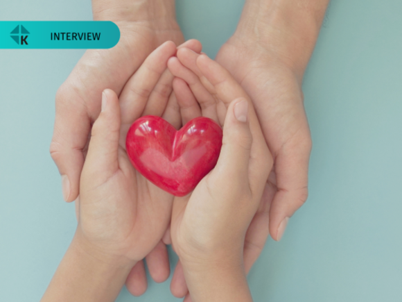 Ein rotes geformtes Herz in zwei Händen