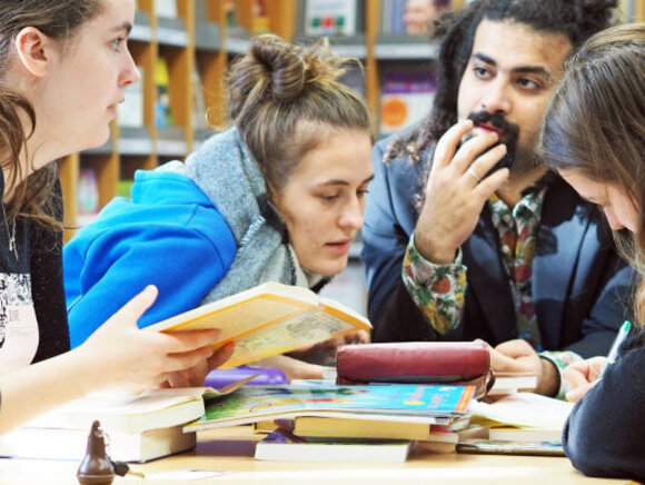 Studierende diskutieren in der Bibliothek