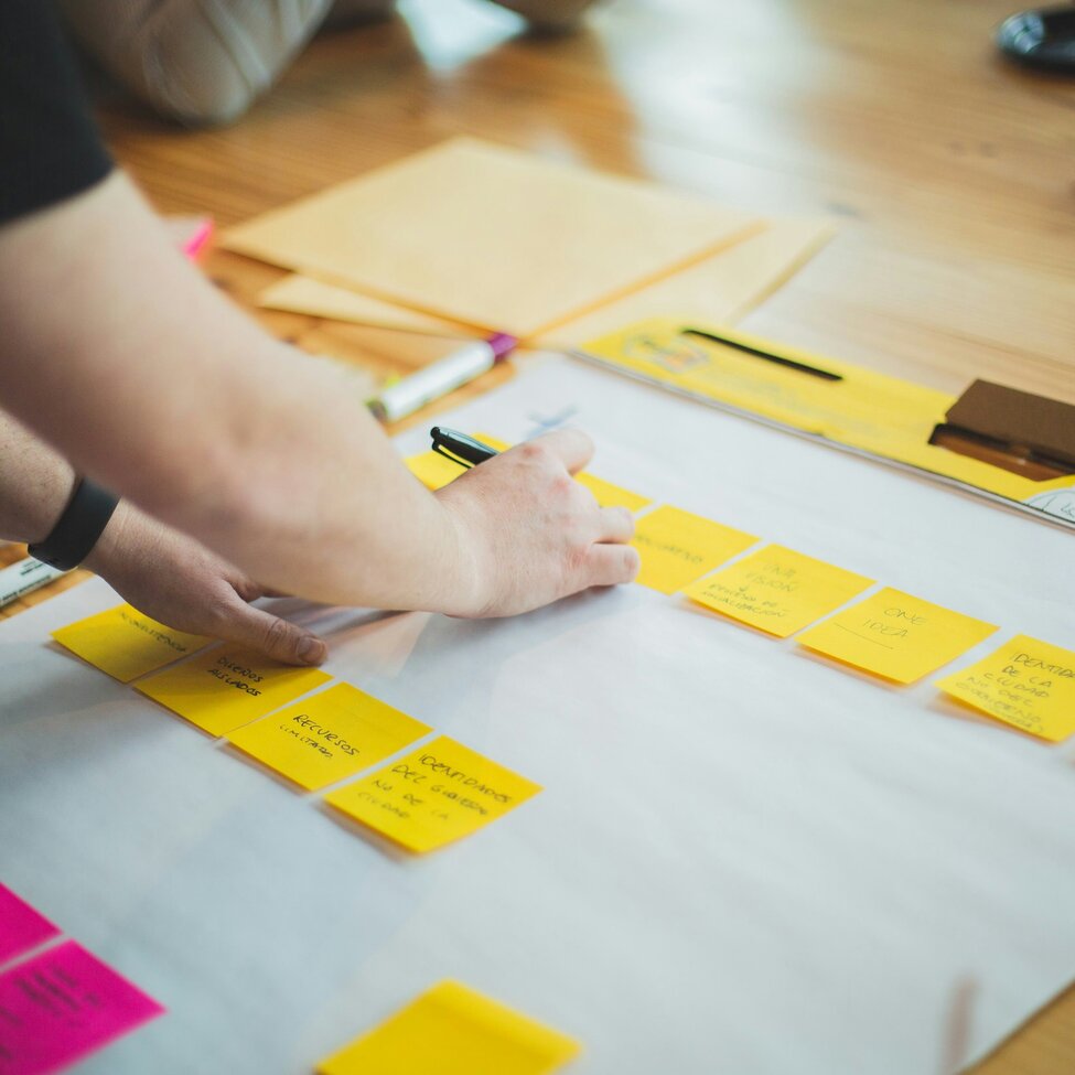 Personen beschriften Post-Its bei einem Workshop