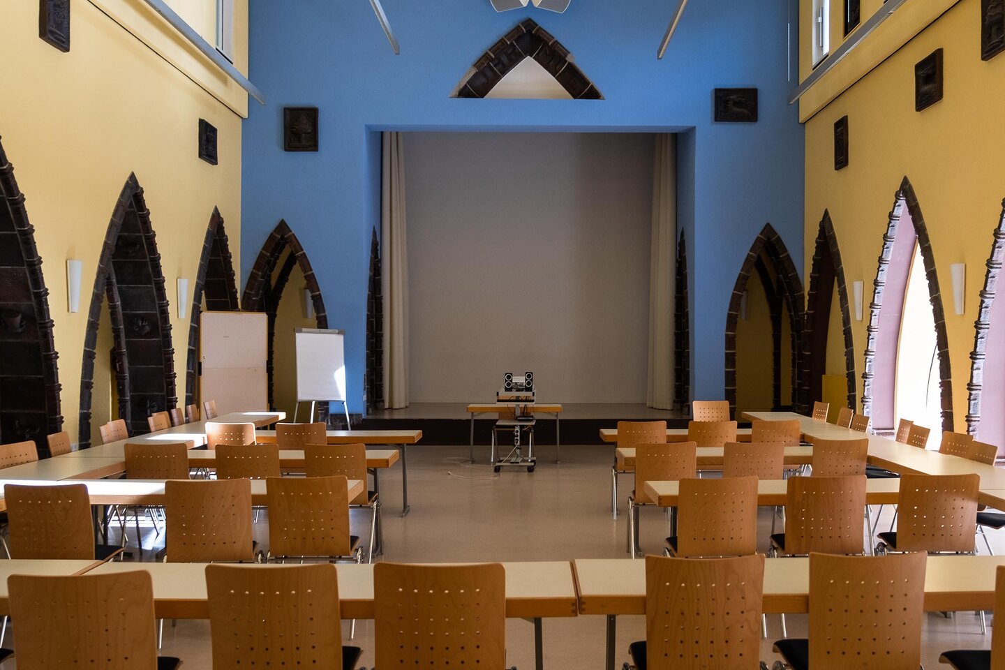 In der Aula der KHSB stehen Stühle und Tische für eine Veranstaltung bereit.