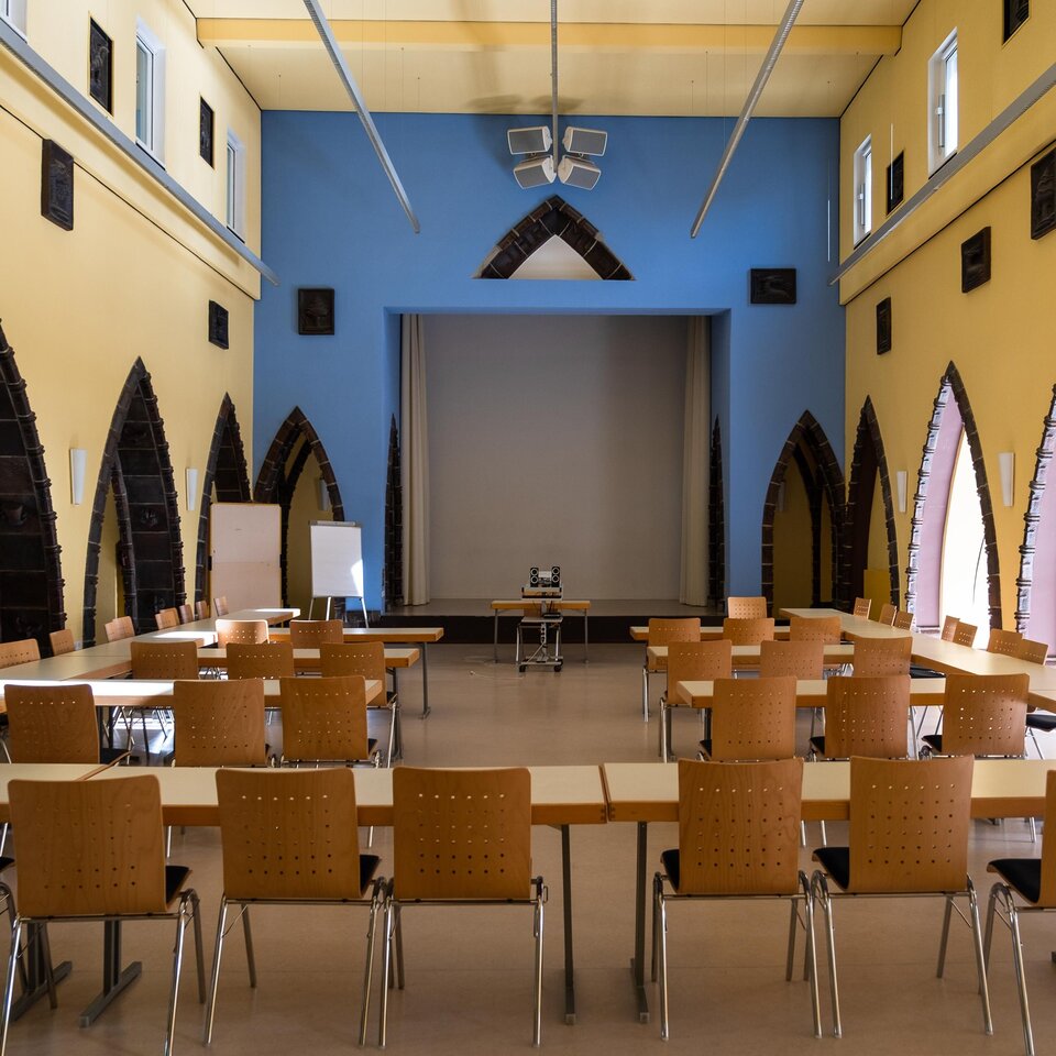 In der Aula der KHSB stehen Stühle und Tische für eine Veranstaltung bereit.