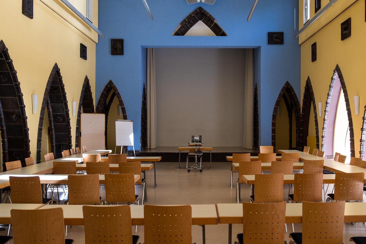 In der Aula der KHSB stehen Stühle und Tische für eine Veranstaltung bereit.