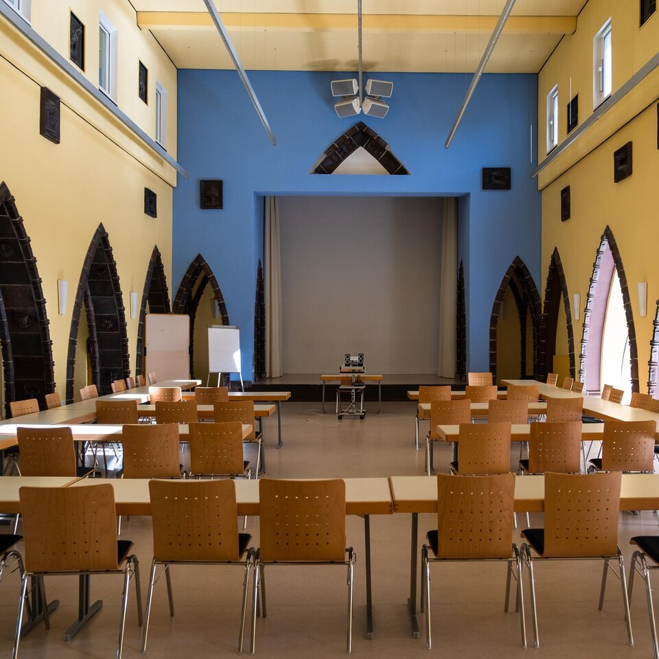 In der Aula der KHSB stehen Stühle und Tische für eine Veranstaltung bereit.