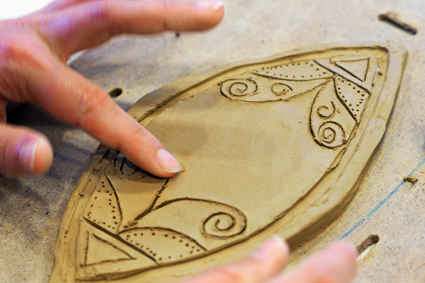 Ein kunstvoll gestaltetes Tonornament mit filigranen Details ist zu sehen.