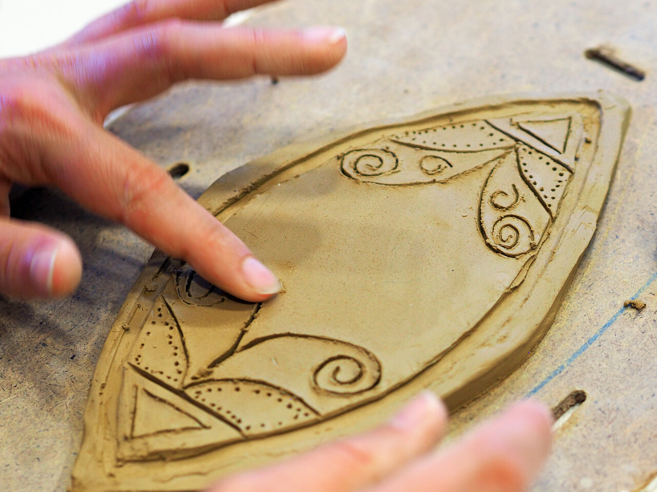 Ein kunstvoll gestaltetes Tonornament mit filigranen Details ist zu sehen.