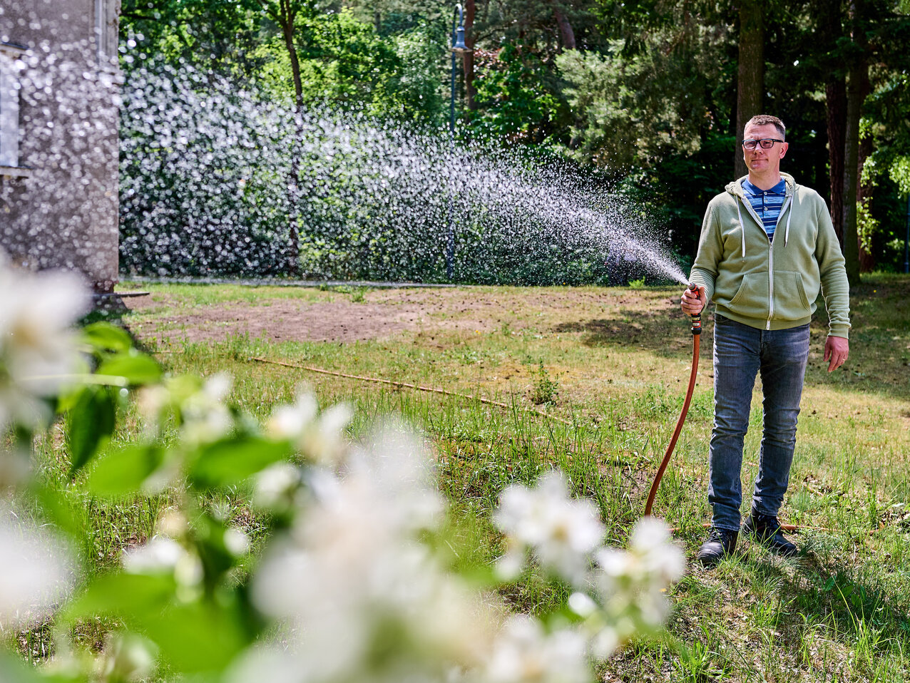 Ein Mitarbeiter der KHSB wässert die Pflanzen auf dem Hochschulgelände.